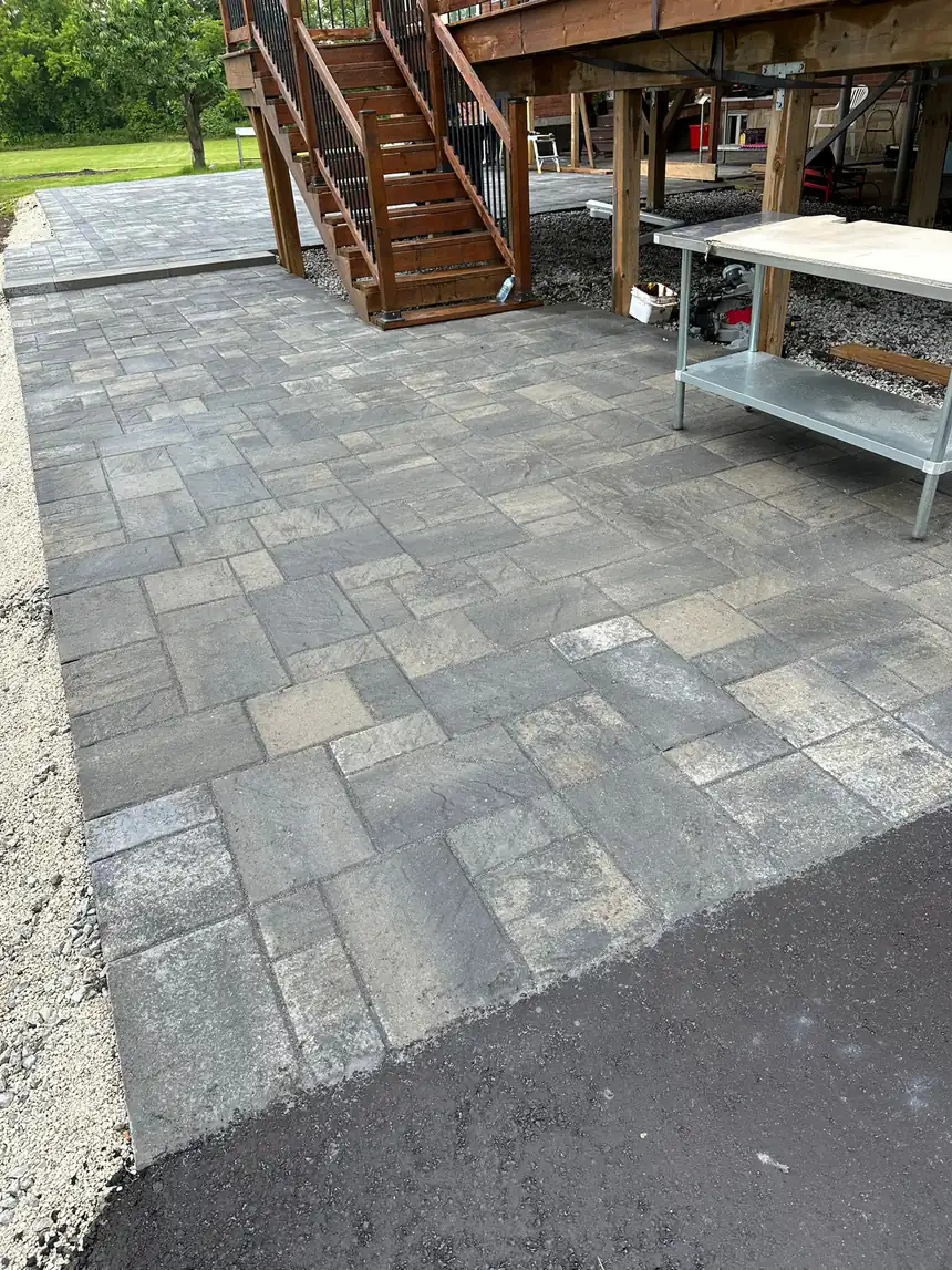 Interlock patio beneath a raised deck by World Gate Landscaping